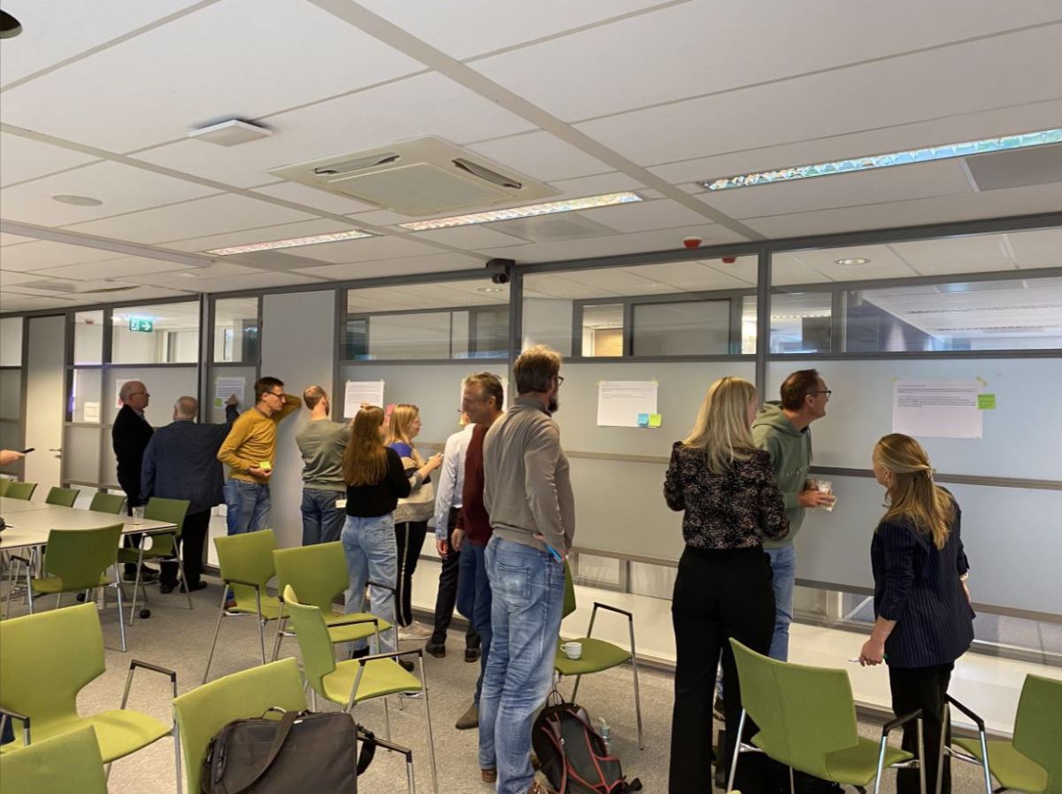 Zib-transitie zesde werksessie. Groep personen plakken post-its op bijbehorende vragen